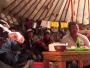 Un groupe de randonneurs est accueilli par une famille de pasteurs nomades dans sa yourte.