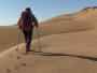 Randonneuse qui monte à pied une dune de sable en Mongolie