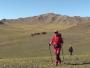 Un randonneur marche dans la steppe mongole montagneuse.