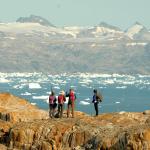 Des randonneurs longent le fjord Sermilik chargé d'icebergs au Groenland Est.