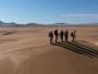 5 randonneurs marchent sur une dune de sable en Mongolie.